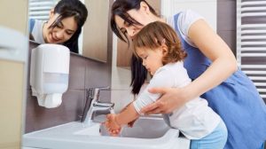 Mom helping kid use single lever faucet 