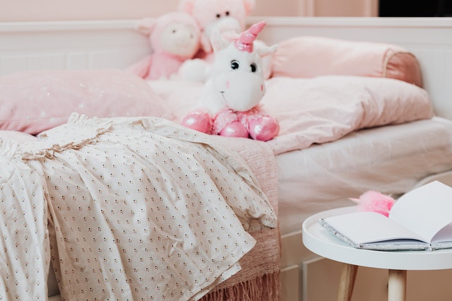 Pink and white plush toys on the bed