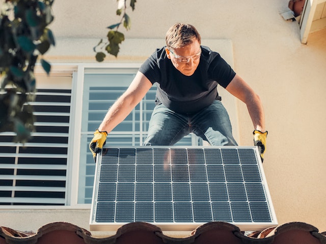 Image of A man installing solar panels