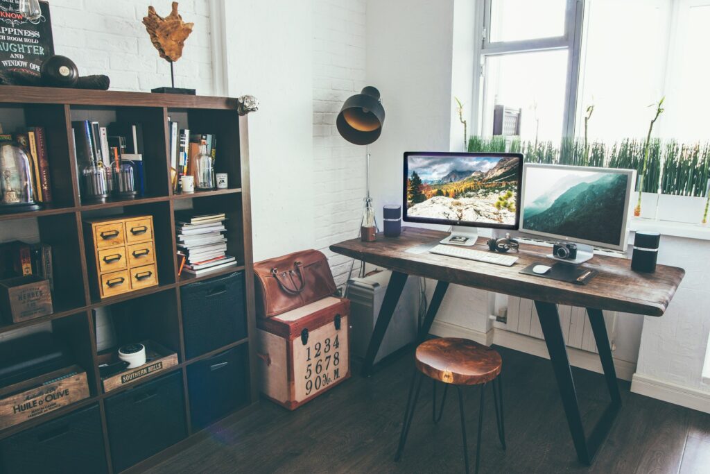 A PC desk next to a wooden cabinet.